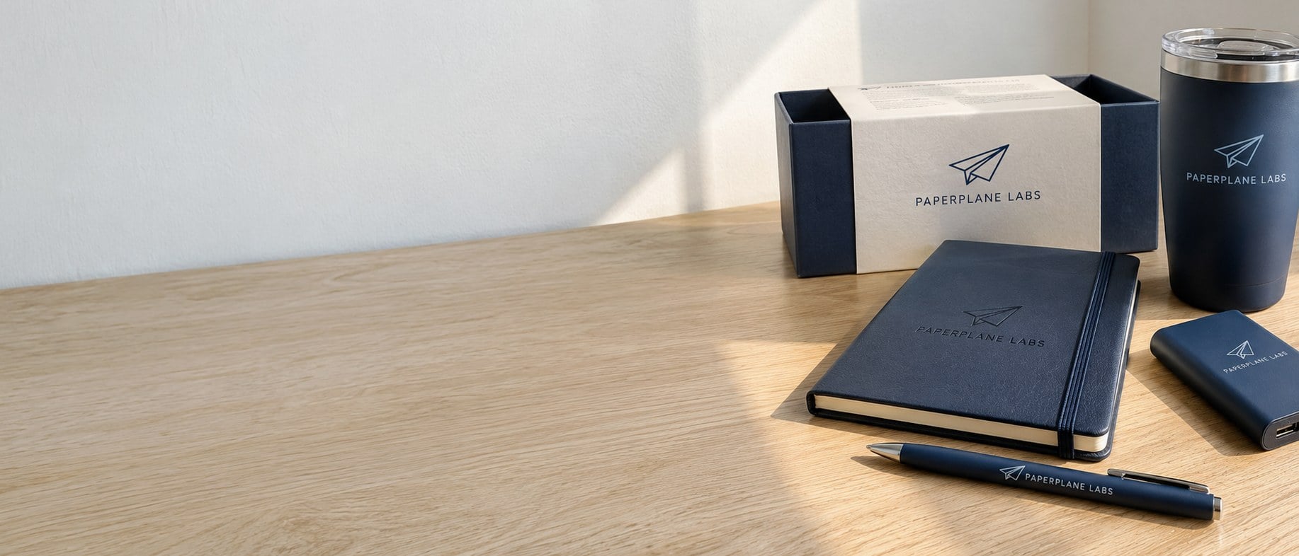 Custom branded corporate gift boxes with drinkware and notebooks on a table